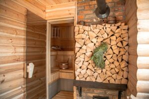 Interior of a wooden Russian sauna with traditional items for use.